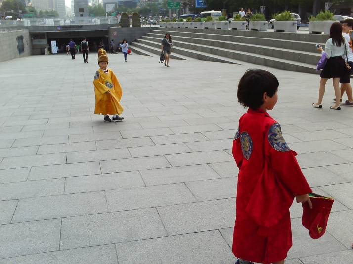 Two kids trying on Joseon Dynasty ceremonial robes near Gyeongbokgung Palace